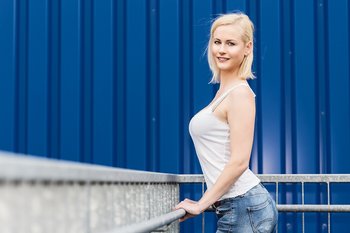 Amazing blonde girl posing in a white shirt outdoors