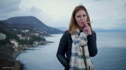 Russian babe with scarf smoking a cigarette by the river — 3