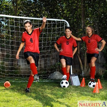Three sexy girls warm up on the soccer field before tak