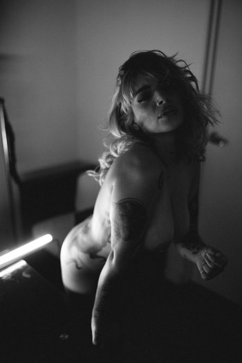 Redhead chick with tattoos puts her naked body on display