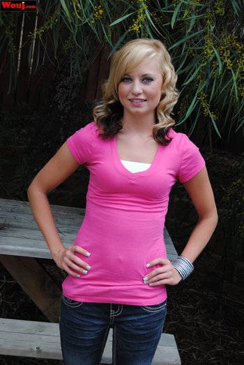 Cute looking girl posing in a pink shirt and jeans outdoors - 000002
