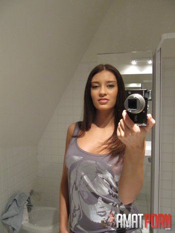 Sizzling brunette stripping in front of the mirror