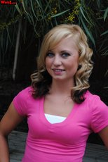 Cute looking girl posing in a pink shirt and jeans outdoors — 9