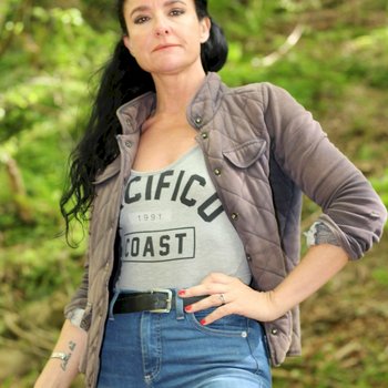 Jolie nana brune posant dans une chemise et un jean bleu à l'extérieur