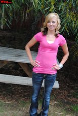 Cute looking girl posing in a pink shirt and jeans outdoors — 2