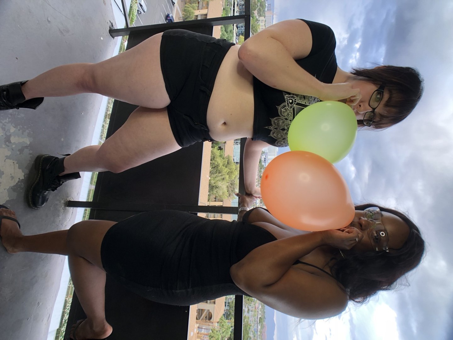 Seksowna Kassey Starr i panna Jane dmuchają balony na balkonie