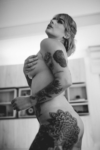 Redhead chick with tattoos puts her naked body on display - 000000