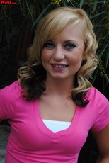 Cute looking girl posing in a pink shirt and jeans outdoors — 10