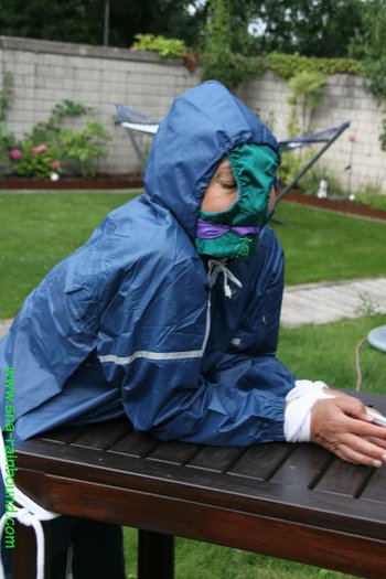 Babe enjoying bondage in her old-school rain-suit and panties on the head - SNA-Rainbound-Nylon  (11)