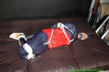 Hot babe being tied in her shiny nylon rainwear